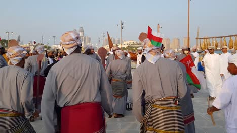 Oman-local-people-are-dancing-togeyhet-in-indipendent-national-day-in-doha-qatar-fifa-football-world-cup-ceremony-tournoment-in-autumn-2022-in-the-sea-side-beach-in-katara-with-instrument-music-boat