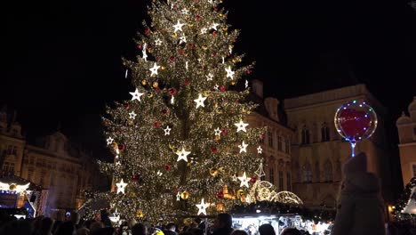 Crowd-of-people-under-Christmas-tree-at-Prague-Christmas-market,-night