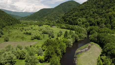 Lush-green-river-valley-with-trees-and-hills-near-Tkibuli,-Georgia
