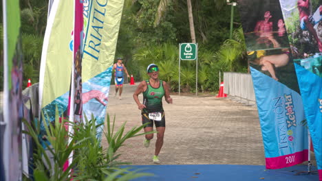 Slow-motion-of-a-happy-female-triathlon-athlete-finishing-the-competition-smiling-looking-exhausted