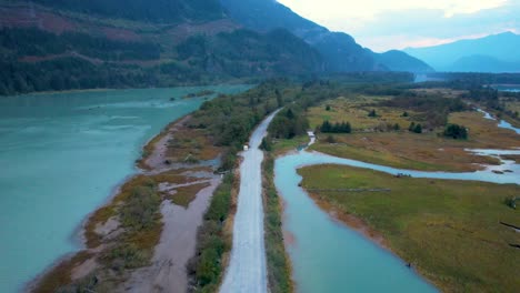 aerial-view-of-Squamish-Spit-conservation-area-Canada-landscape-at-sunset-with-narrowed-gravel-road-and-scenic-mountains-view