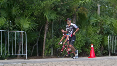 Slow-motion-of-a-group-of-athletes-competing-in-a-triathlon-running-and-riding-bicycles