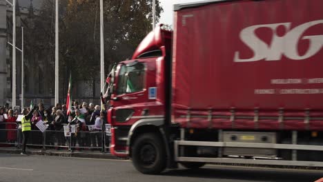 30-November-2022---London-Red-Bus-And-Traffic-Going-Past-Iran-Protest-Outside-Houses-Of-Parliament-On-Parliament-Square