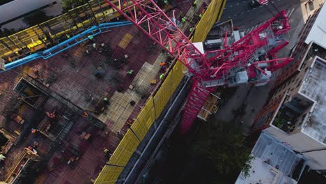 Aerial-view-rising-in-front-of-a-crane-at-a-rooftop-construction-site-in-NY,-USA