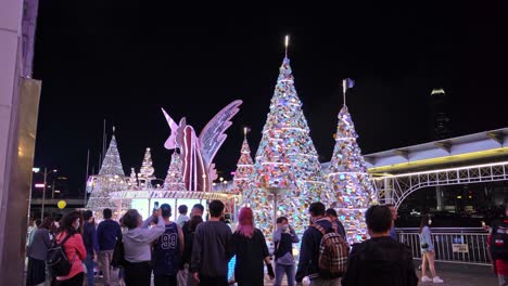 Touristen-Besuchen-Einhorn-Weihnachtsdekorationen-Außerhalb-Der-Hafenstadt-In-Tsim-Sha-Tsui,-Hongkong