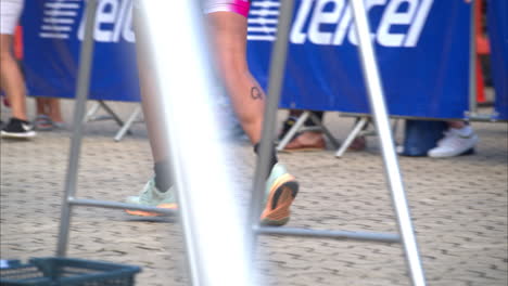 Slow-motion-of-a-female-athlete-legs-jogging-starting-the-running-stage-at-a-triathlon-inside-the-transition-zone