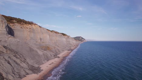 High-drone-shot-moving-right-along-next-to-the-cliffs-on-the-Jurassic-Coast-on-a-summer-day,-Dorset,-UK