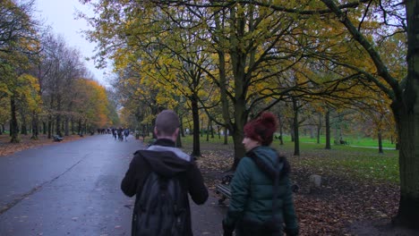 People-Walking-On-Tree-Lined-Road-With-Autumn-Foliage-In-Regents'-Park,-Camden,-London,-UK