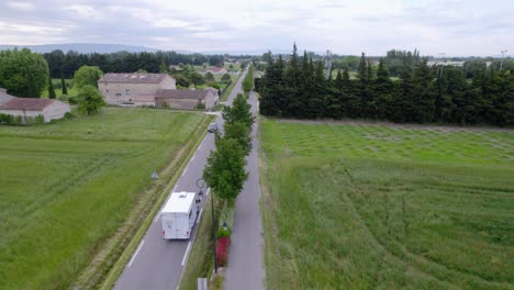 Aerial-view-over-a-road-with-a-car-and-a-telecom-van-driving-in-the-opposite-direction