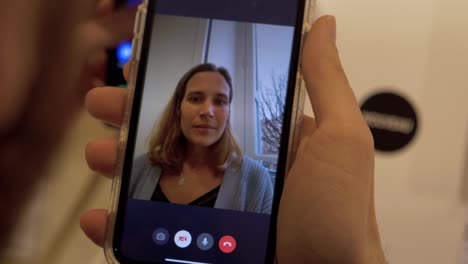 Slowmotion-rotating-shot-of-a-young-woman-on-a-video-call-on-a-smartphone