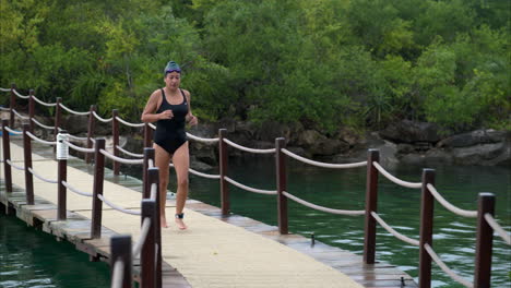 Slow-motion-of-a-woman-athlete-running-crossing-a-bridge-in-a-transition-at-a-triathlon-competition