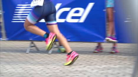 Slow-motion-of-an-athlete-legs-starting-the-running-stage-at-a-triathlon-inside-the-transition-zone