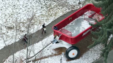 Tight-shot-of-people-playing-on-the-big-red-wagon-in-Spokane,-Washington's-downtown-riverfront-park-in-the-winter