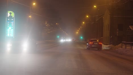 Car-driving-on-city-street-at-night-time-and-fog,-static-view