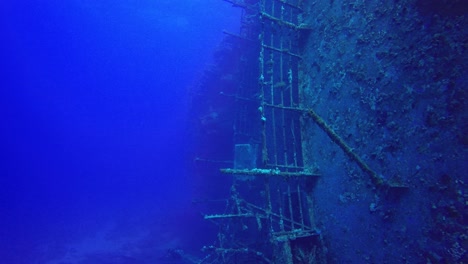 Diving-along-shipwreck-lying-side-ways-underwater-in-the-Red-Sea