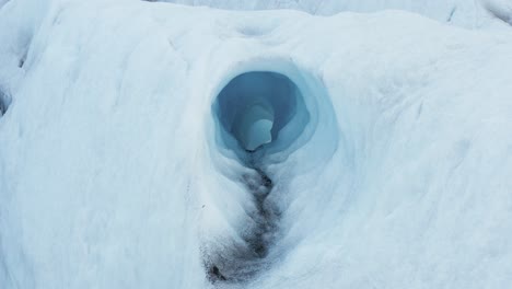 Ice-tunnel-created-by-water-erosion-inside-frozen-glacier,-global-warming
