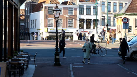 Slow-motion-shot-of-pedestrian-and-cyclist-on-central-road-of-Leiden-City-during-sunny-day---Oldest-university-town-in-Netherlands