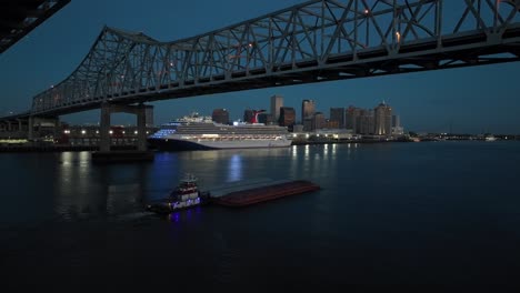 Karnevals-Kreuzfahrtschiff-Am-Dock-In-New-Orleans,-Während-Das-Dampfschiff-Nachts-Den-Lastkahn-Schiebt