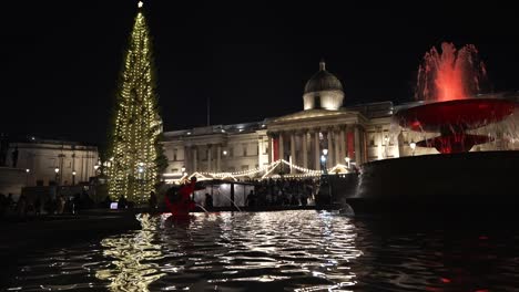 Trafalgar-Square-Christmas-Tree,-Market-Lights-Reflected-In-Fountains