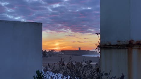Farbenfrohe-Sonnenuntergangsskyline-über-Der-Stadtsilhouette-In-Der-Abenddämmerung-Mit-Dramatischem-Orange-rot-gelbem-Himmel-Und-Wolken,-Die-Sich-über-Die-Stadt-Bewegen