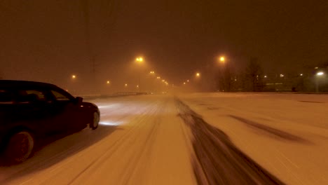 POV-shot-driving-along-a-snow-covered-highway-with-a-car-passing-in-Helsinki