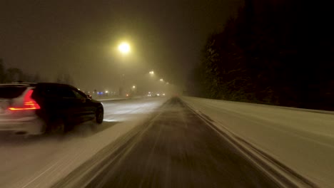 POV-shot-traveling-along-a-highway-with-other-cars-spraying-up-snow