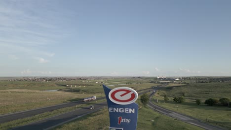 Highway-aerial-descends-to-reveal-prominent-Engen-petrol-station-sign