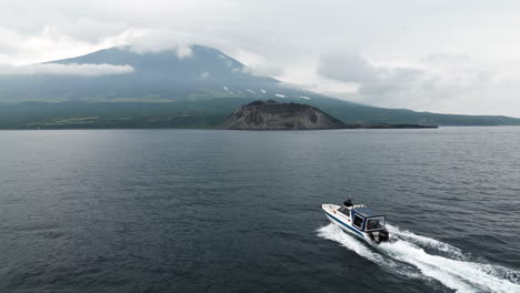 El-Barco-Navega-Hacia-Una-Isla-Salvaje-Con-Un-Volcán