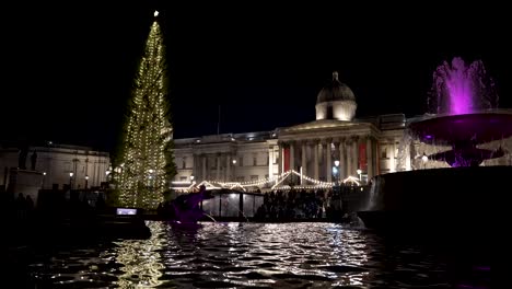 Trafalgar-Square-Christmas-Tree,-Market-Lights-Reflected-In-Fountains