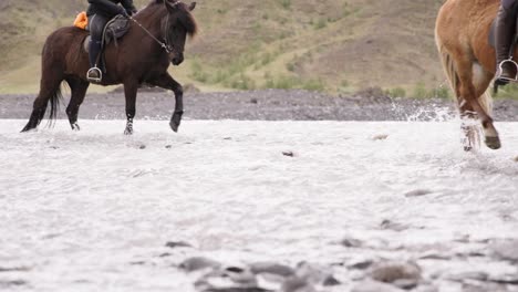 Tourist-horseback-riding-through-shallow-glacial-river-in-Iceland