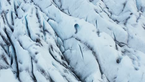 Glacier-surface-with-fissured-ice-cracks,-Iceland,-aerial