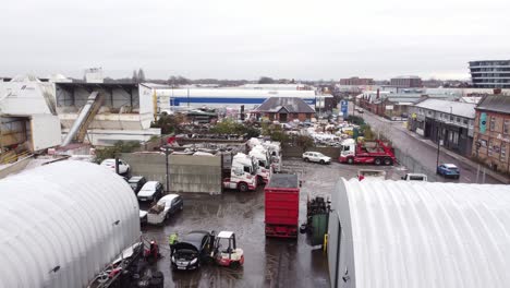 Aerial-view-rising-over-backstreet-city-industrial-truck-yard-mechanics-workplace