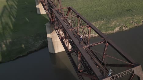 People-use-abandoned-rail-bridge-to-cross-Vaal-River-at-Villiers,-ZA
