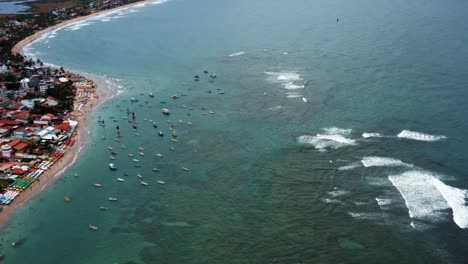 Luftdrohnenweite-Aufnahme-Des-Berühmten-Porto-De-Galinhas-Oder-Hühnerhafenstrandes-Mit-Dutzenden-Von-Verankerten-Segelbooten-Und-Hunderten-Von-Touristen,-Die-Im-Kristallklaren-Meerwasser-In-Pernambuco,-Brasilien,-Schwimmen