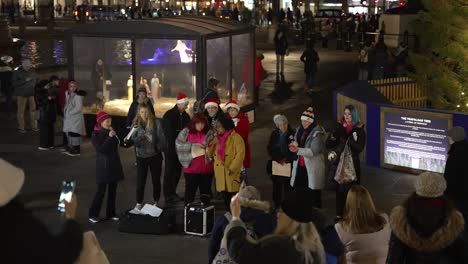 Female-Carol-Choir-Group-Singing-At-Trafalgar-Square-At-Christmas-In-Front-Of-Watching-Public
