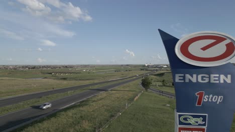 Aerial:-Large-Engen-station-sign-and-highway-traffic-in-South-Africa