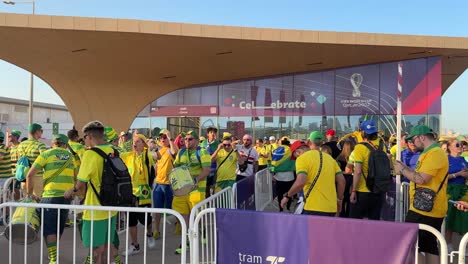 Fröhliche-Menge-Brasilianischer-Fußballliebhaber-Mit-Gelbgrüner-Flagge-Und-Trikot-Stehen-In-Der-Warteschlange,-Um-Das-Spiel-Bei-Der-Weltmeisterschaft-Zu-Sehen