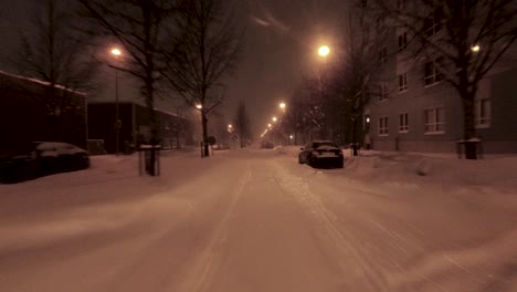 POV-shot-driving-through-the-snowy-streets-of-Helsinki-with-parked-cars