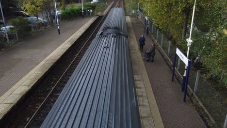 Viewpoint-above-train-carriage-rooftop-arriving-at-station-tilt-reveal-to-long-tracks-into-distance