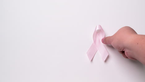 Detail-of-male-hand-holding-ribbon-in-light-purple-color-over-white-background