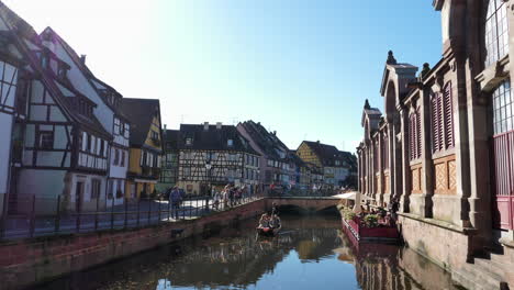 Tourists-sailing-along-canal-in-old-town-of-Little-Venice-in-Colmar,-France