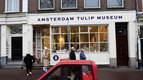 Cámara-Lenta-De-Turistas-Caminando-Frente-Al-Museo-De-Tulipanes-De-Amsterdam-Durante-El-Día