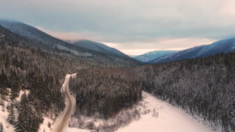 Beautiful-Drone-Pullback-Shot-of-Cloudy,-Tree-Covered-Mountains-in-the-Thompson-Nicola-Region,-BC,-Canada-in-winter