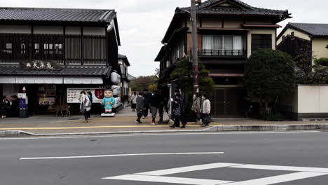 Tourists-Walking-Along-Street-with-Traditional-Buildings,-Nara,-Japan