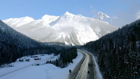Cargo-Trucks-and-Cars-Driving-on-Scenic-Trans-Canada-Highway-1-Surrounded-by-Majestic-Mountains-on-Sunny-Winter-Day-Near-Revelstoke,-British-Columbia,-Canada