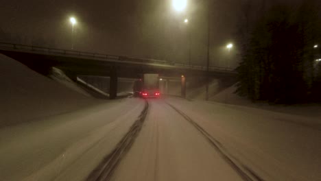 POV-shot-following-delivery-trucks-driving-along-a-snowy-highway-in-Helsinki
