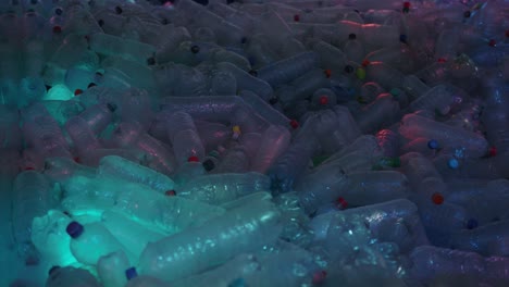 General-shot-of-many-empty-water-bottles-with-colored-caps-illuminated-with-colored-light