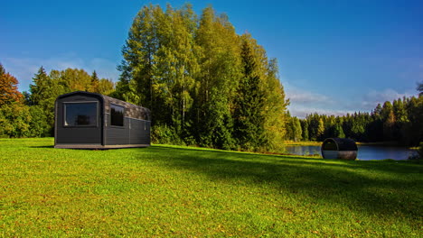 Time-laps-of-modern-cabin-in-an-open-grassland-space-near-a-lake-and-forest