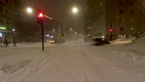 POV-static-shot-waiting-at-traffic-lights-with-pedestrians-crossing-in-the-Snow-storm