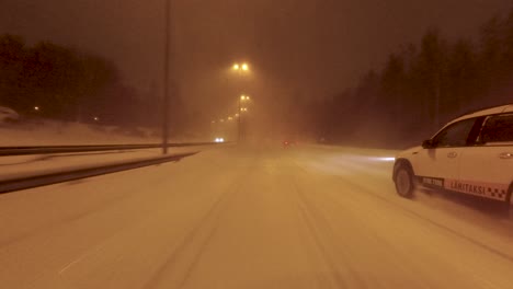 POV-shot-driving-along-a-snow-covered-road-with-snow-being-lifted-reducing-visibility